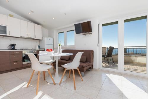 eine Küche und ein Wohnzimmer mit einem Tisch und Stühlen in der Unterkunft Apartments with a parking space Makarska - 22017 in Makarska