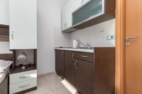 eine kleine Küche mit einem Waschbecken und einem Spiegel in der Unterkunft Apartments with a parking space Makarska - 22017 in Makarska