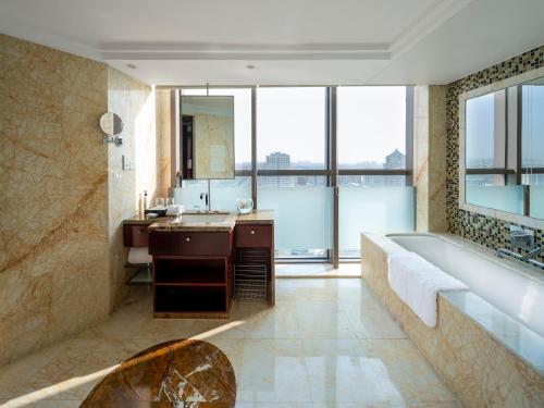 y baño con bañera y lavamanos. en Songjiang New Century Grand Hotel Shanghai, en Songjiang