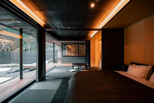 ein Schlafzimmer mit einem Bett und einem großen Fenster in der Unterkunft UMEGASHIMA　DRIVEｰIN　＆　SAUNA　VILLA in Shizuoka
