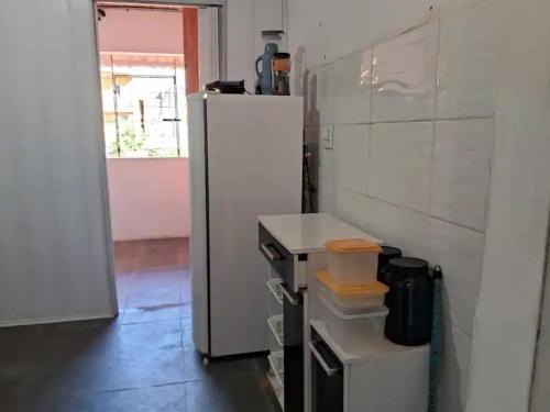 a kitchen with a white refrigerator in a room at Apartamento em Ilhéus in Ilhéus