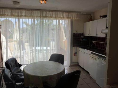 une cuisine avec une table et des chaises et une fenêtre dans l'établissement Résidence Héliopolis Bâtiment C - Héliopolis Bât. C studio 2 Pers. MAE-4414, au Cap d'Agde
