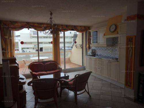 une cuisine avec des chaises, une table et une fenêtre dans l'établissement Résidence Héliopolis Bâtiment C - Héliopolis Bât. C studio 4 Pers. MAE-4504, au Cap d'Agde