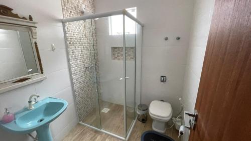 een badkamer met een douche, een toilet en een wastafel bij Linda casa triplex 50 metros do mar in Governador Celso Ramos