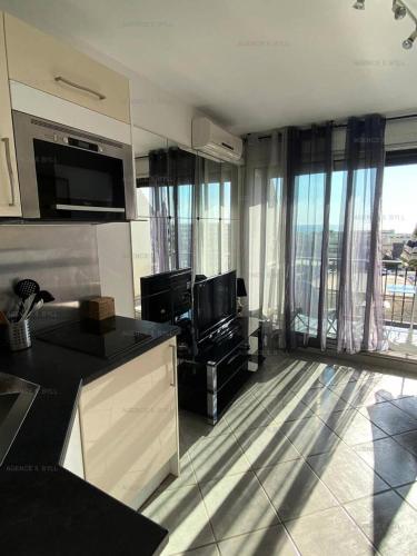 Il comprend une cuisine et un salon avec une grande fenêtre. dans l'établissement Résidence Héliopolis Bâtiment Fgh - Studio 2 couchages CAP d'AGDE MAE-4574, au Cap d'Agde