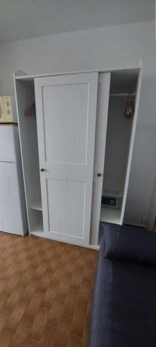 une pièce vide avec des armoires blanches et un canapé dans l'établissement Résidence Héliopolis Bâtiment Ab - Studio Cabine 4 pers - Héliopolis Bât. AB MAE-4624, au Cap d'Agde