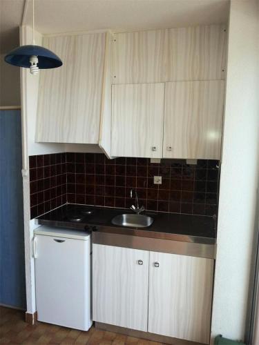 une cuisine avec des armoires blanches et un évier dans l'établissement Résidence Héliopolis Bâtiment Ab - Studio -2 pers Héliopolis Bat. AB MAE-5464, au Cap d'Agde