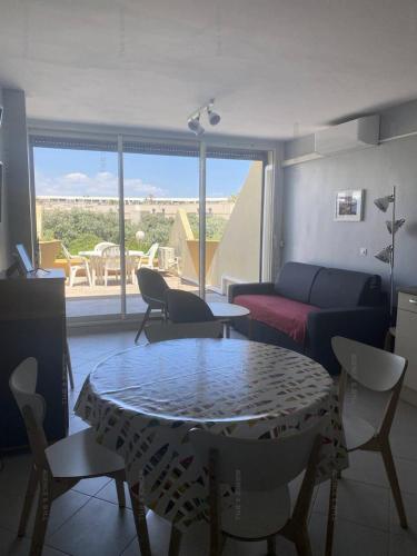 un salon avec une table et un canapé dans l'établissement Résidence Héliopolis Bâtiment E - STUDIO 2 pers. HELIOPOLIS Bâtiment E MAE-5494, au Cap d'Agde