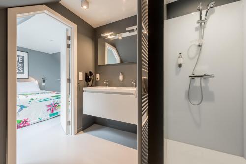 een badkamer met een douche, een wastafel en een bed bij Smartflats Design - Postiers in Brussel