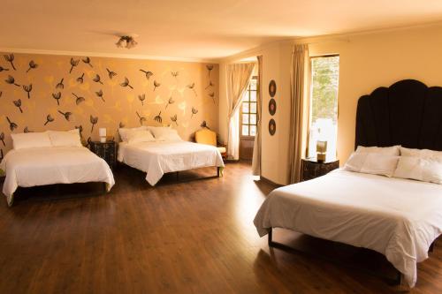 1 dormitorio con 2 camas con pájaros en la pared en Golden House guesthouse en Cochabamba