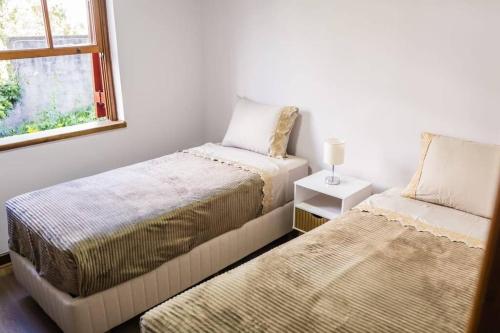 een slaapkamer met 2 bedden en een raam bij Quatro Estações Hospeda L 11 - Conforto para família no Capivari in Campos do Jordão