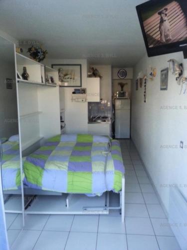 een kleine slaapkamer met een bed en een keuken bij Résidence Port Nature Colline 2 - Studio pour 2 Personnes 191 in Cap d'Agde