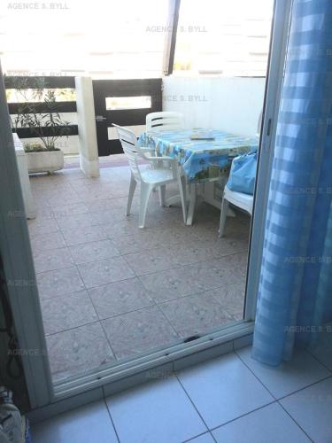 een patio met een tafel en stoelen op een balkon bij Résidence Port Nature Colline 2 - Studio pour 2 Personnes 191 in Cap d'Agde
