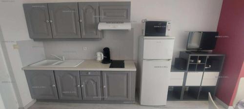 une petite cuisine avec un évier et un réfrigérateur dans l'établissement Résidence Héliopolis Bâtiment K - Héliopolis Bâtiment K appartement avec Chambre séparée 4 pers MAE-2854, au Cap d'Agde