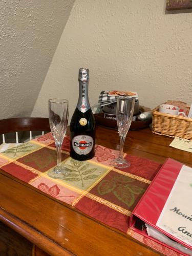 a bottle of wine sitting on a table with two glasses at Mountain Meadows Inn & Chalet Suites in Ashford
