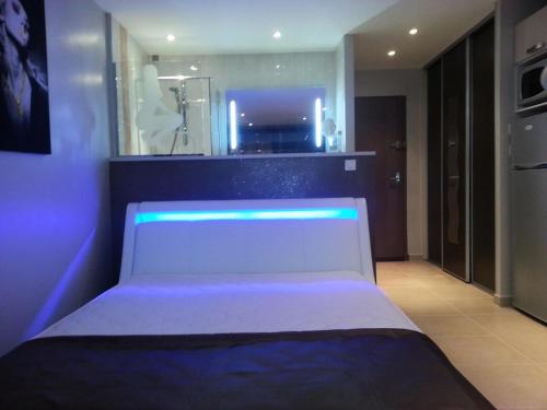 - une chambre avec un lit blanc et des lumières bleues dans l'établissement Résidence Héliopolis Bâtiment L - Studio 4 pers. CAP d'AGDE MAE-1281, au Cap d'Agde