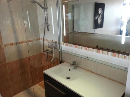 une salle de bain avec un lavabo et une douche avec un miroir dans l'établissement Résidence Héliopolis Bâtiment L - Studio 4 pers. CAP d'AGDE MAE-1281, au Cap d'Agde