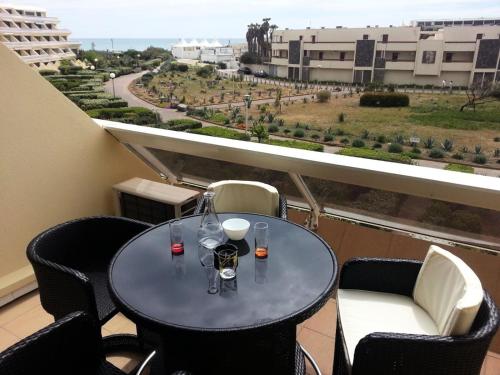 une table et des chaises sur un balcon avec vue dans l'établissement Résidence Héliopolis Bâtiment L - Studio 4 pers. CAP d'AGDE MAE-1281, au Cap d'Agde