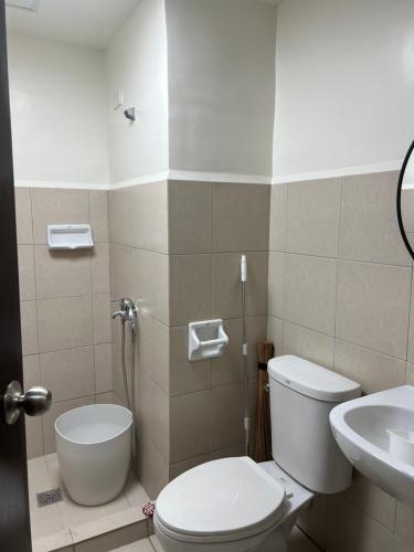 a bathroom with a toilet and a sink at Kristinas Homestay- Cozy Resort Vibe Condotel in Cebu City