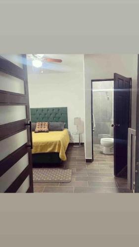 a bedroom with a bed and a bathroom with a toilet at Lovely and warming 3 bed in Morelia