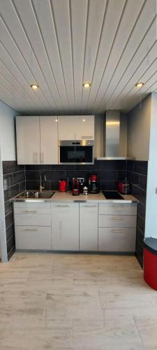 une grande cuisine avec des placards blancs et un plafond dans l'établissement Résidence Héliopolis Bâtiment D - Héliopolis Bât. D studio 4 Pers. MAE-3054, au Cap d'Agde