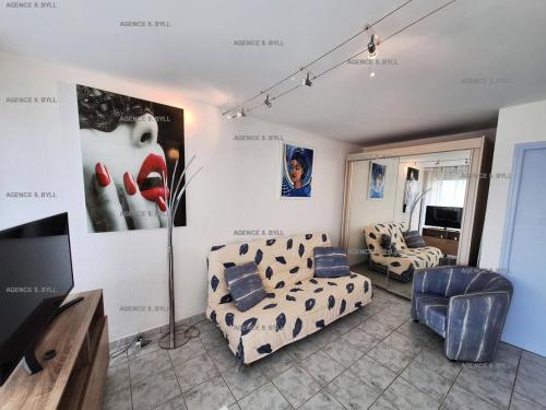 un salon avec des canapés et une télévision à écran plat dans l'établissement Résidence Héliopolis Bâtiment C - Héliopolis Bât. C studio 2 Pers. MAE-1871, au Cap d'Agde