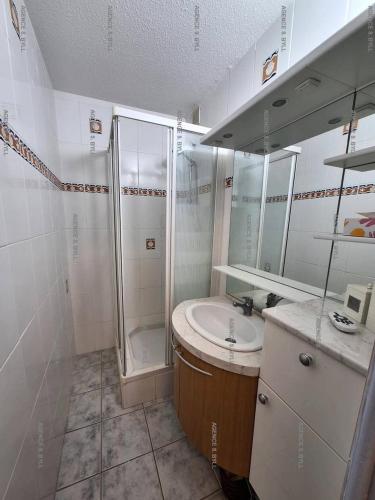 une salle de bain blanche avec une douche et un lavabo dans l'établissement Résidence Héliopolis Bâtiment C - Héliopolis Bât. C studio 2 Pers. MAE-1871, au Cap d'Agde