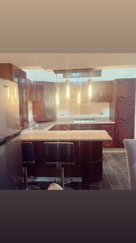 a kitchen with wooden cabinets and a counter top at Lovely and warming 3 bed in Morelia