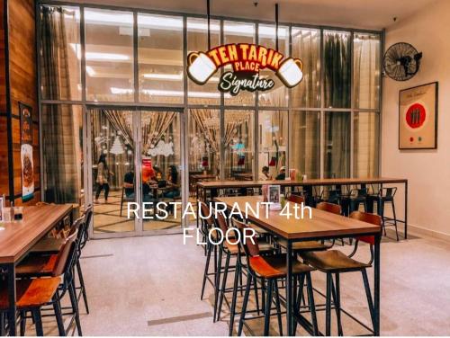 Regalia Exclusive Hostel في كوالالمبور: مطعم فيه طاولات وكراسي امام شباك