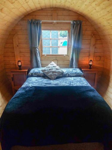 a bedroom with a large bed in a log cabin at Ashley Gorge Holiday Park in Oxford