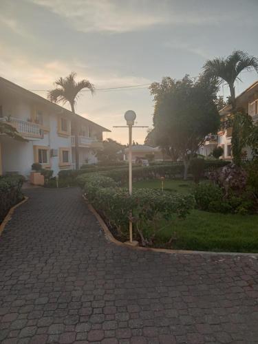 een stenen loopbrug voor een gebouw met palmbomen bij Casitas del sol in Boca Chica