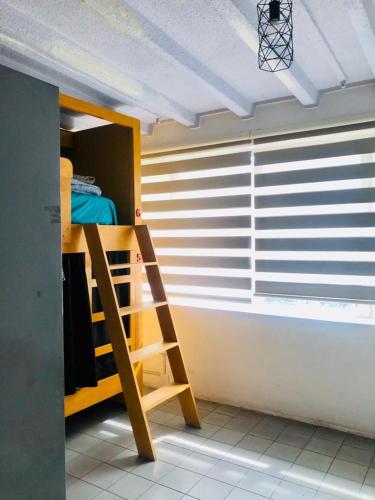 a room with a bunk bed and a ladder at Leveli Coliving in Guadalajara