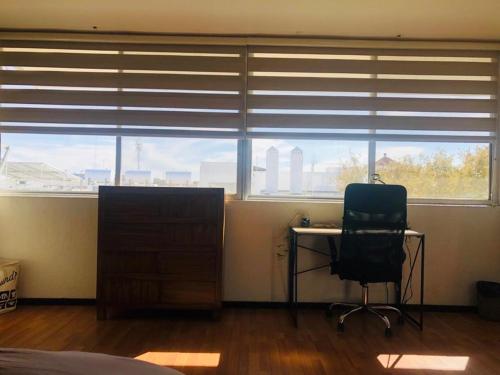 a bedroom with a desk and a chair in front of a window at Leveli Coliving in Guadalajara