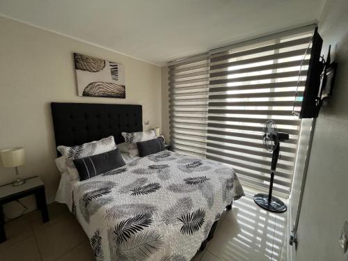 1 dormitorio con 1 cama y ventana con persianas en Amoblados Chilerent Mor, en Santiago