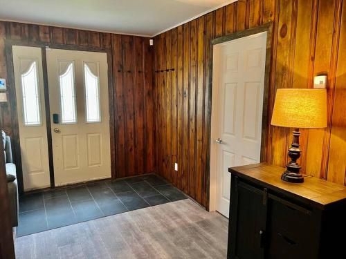 a room with wooden walls and a lamp and two doors at Chalet Plus Canada s.e.n.c. in Saint-Gabriel-de-Brandon