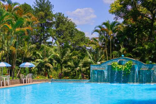 einen Pool in einem Resort mit Stühlen und Sonnenschirmen in der Unterkunft Hotel Estância Santa Isabel in Santa Isabel