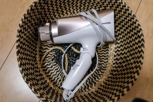 a hair dryer sitting on a table with aumption at 难波站 高岛屋步行5分钟 双层独栋别墅150平 4卧室3厕所2浴室 空间宽敞设施齐全 八阪神社步行1分钟 心斋桥 道顿堀 黑门市场 通天阁步行圈内 in Osaka