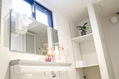 a bathroom with a mirror and a sink at 难波站 高岛屋步行5分钟 双层独栋别墅150平 4卧室3厕所2浴室 空间宽敞设施齐全 八阪神社步行1分钟 心斋桥 道顿堀 黑门市场 通天阁步行圈内 in Osaka
