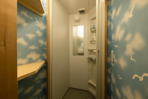 uma pequena casa de banho com um chuveiro com nuvens pintadas na parede em 信州善光寺 薬王院 em Nagano