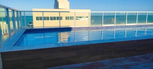 uma piscina ao lado de um edifício em APTO - perto da praia - Piscina - Cabedelo João Pessoa em Cabedelo