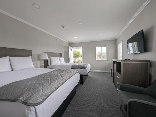 a hotel room with two beds and a flat screen tv at Ocean Park Inn in Los Angeles