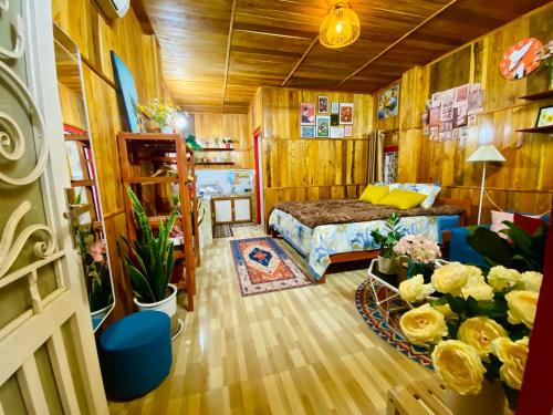 sypialnia z łóżkiem i kwiatami w pokoju w obiekcie Wind Hill Homestay Hà Giang 