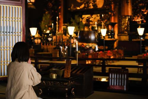 a woman sitting in front of a counter in a room at 信州善光寺 薬王院 in Nagano