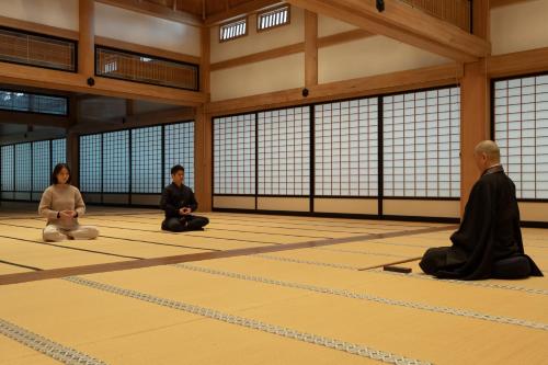 a group of three people sitting in a room at 信州善光寺 薬王院 in Nagano