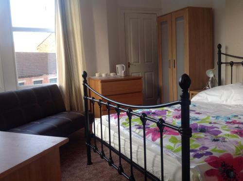 a bedroom with a bed and a couch and a window at Clift Guest House in Bristol