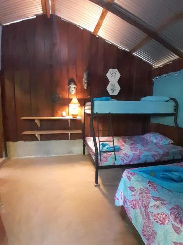 a room with two bunk beds and a table at Los Paniquines Ecolodge in Drake