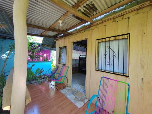 a patio with colorful chairs and a window at Los Paniquines Ecolodge in Drake