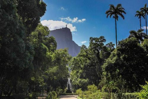 a statue in front of a mountain with trees at OBO Casa • Modern Lux Design Loft • Ipanema Beach in Rio de Janeiro