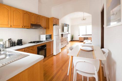 a kitchen with wooden cabinets and a table with chairs at Richmond Delights - 4 Bedrooms and a Big Backyard in Melbourne
