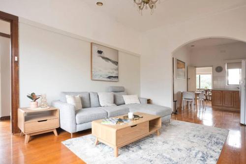 a living room with a couch and a coffee table at Richmond Delights - 4 Bedrooms and a Big Backyard in Melbourne